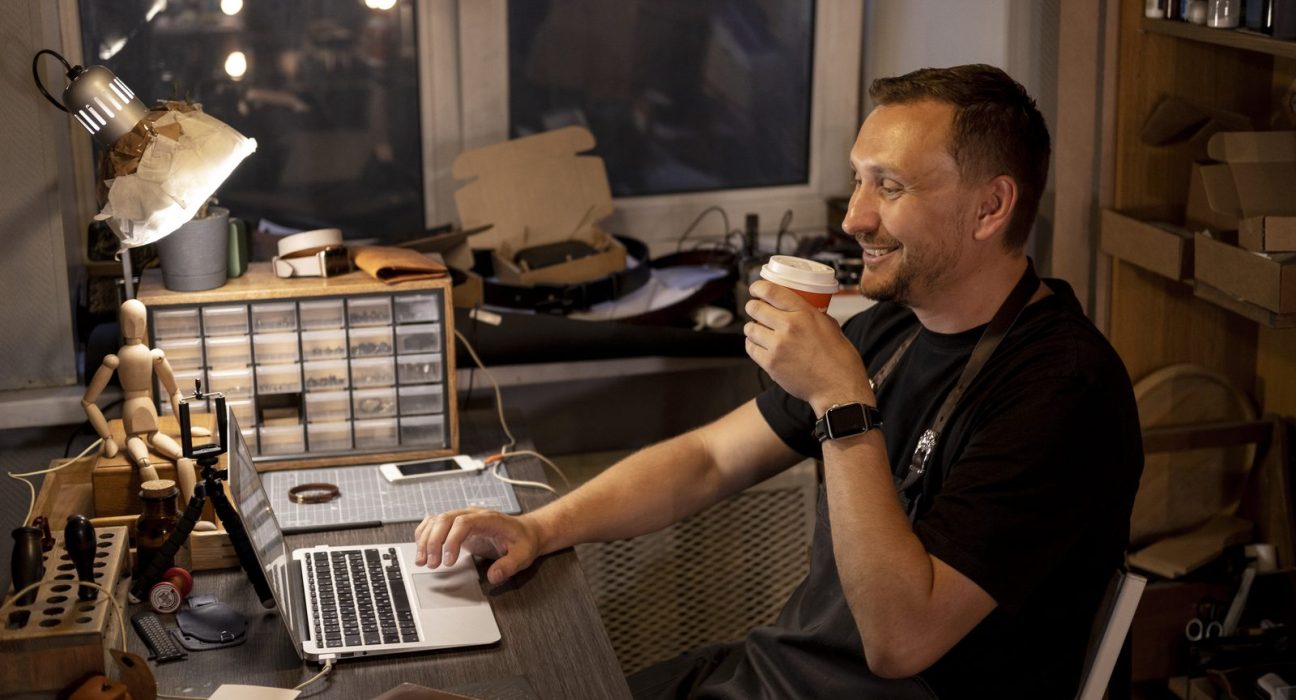 Właściciel małej firmy przy laptopie w swoim warsztacie
